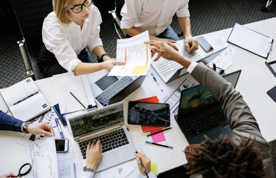 Construction project management team reviewing architectural plans to mitigate change order costs.