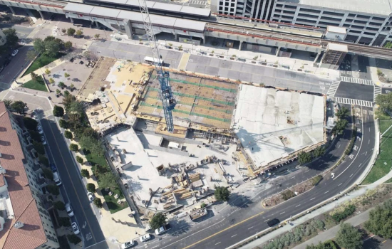 Aerial view of a vibrant mixed-use development with green spaces, high-rises, and community plazas in Dubai